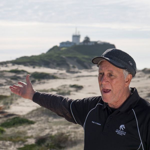 Associate Professor Ron Boyd on Nobby's beach with headland in background. Launch of Newcastle Geotrail to celebrate National Science Week