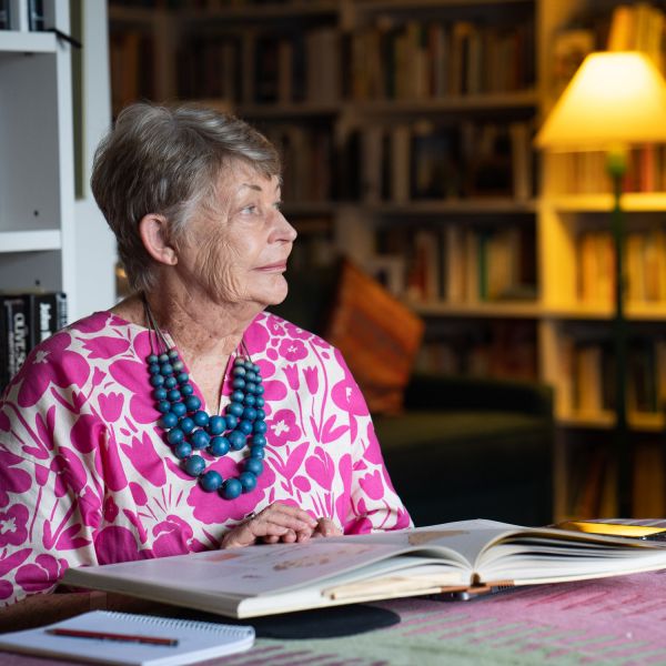 portrait of Professor Lyndall Ryan in her home studying a book