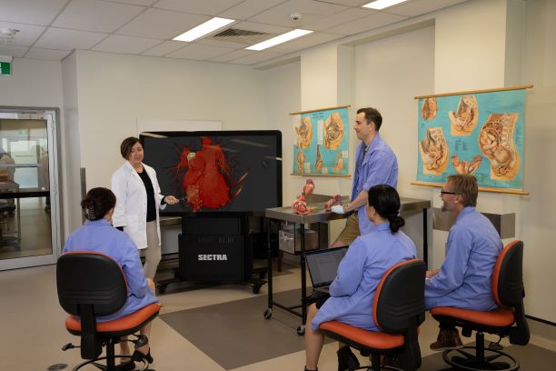 Lab office room with people sitting and talking with computers.