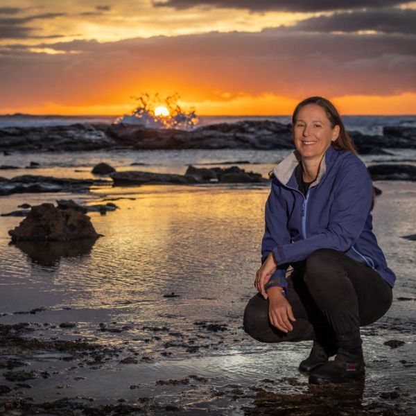 Dr Megan Huggett Dr Megan Huggett on a rock platform at sunrise.