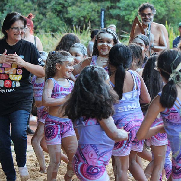 Wollotuka institute head Kath Butler dances with children in the sand