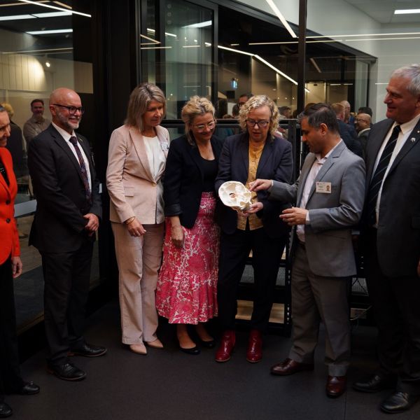 A group of people standing together looking at a 3D printed skull. First Health Innovation Living Lab opens in the Hunter