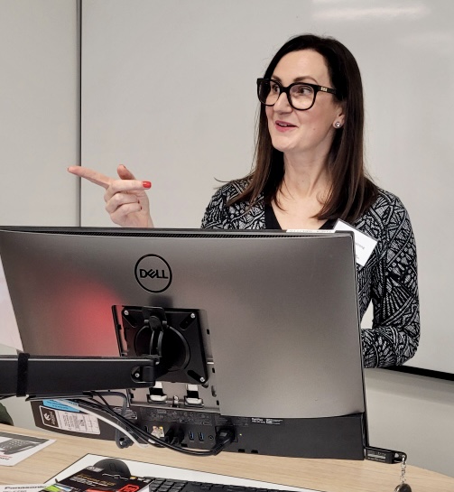 Christine Armstrong during her presentation. She is pictured looking and pointing towards the left.