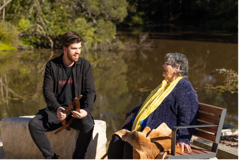 Dr Hodgetts and his nana, Anita, sing along to a song as they sit by a creek.