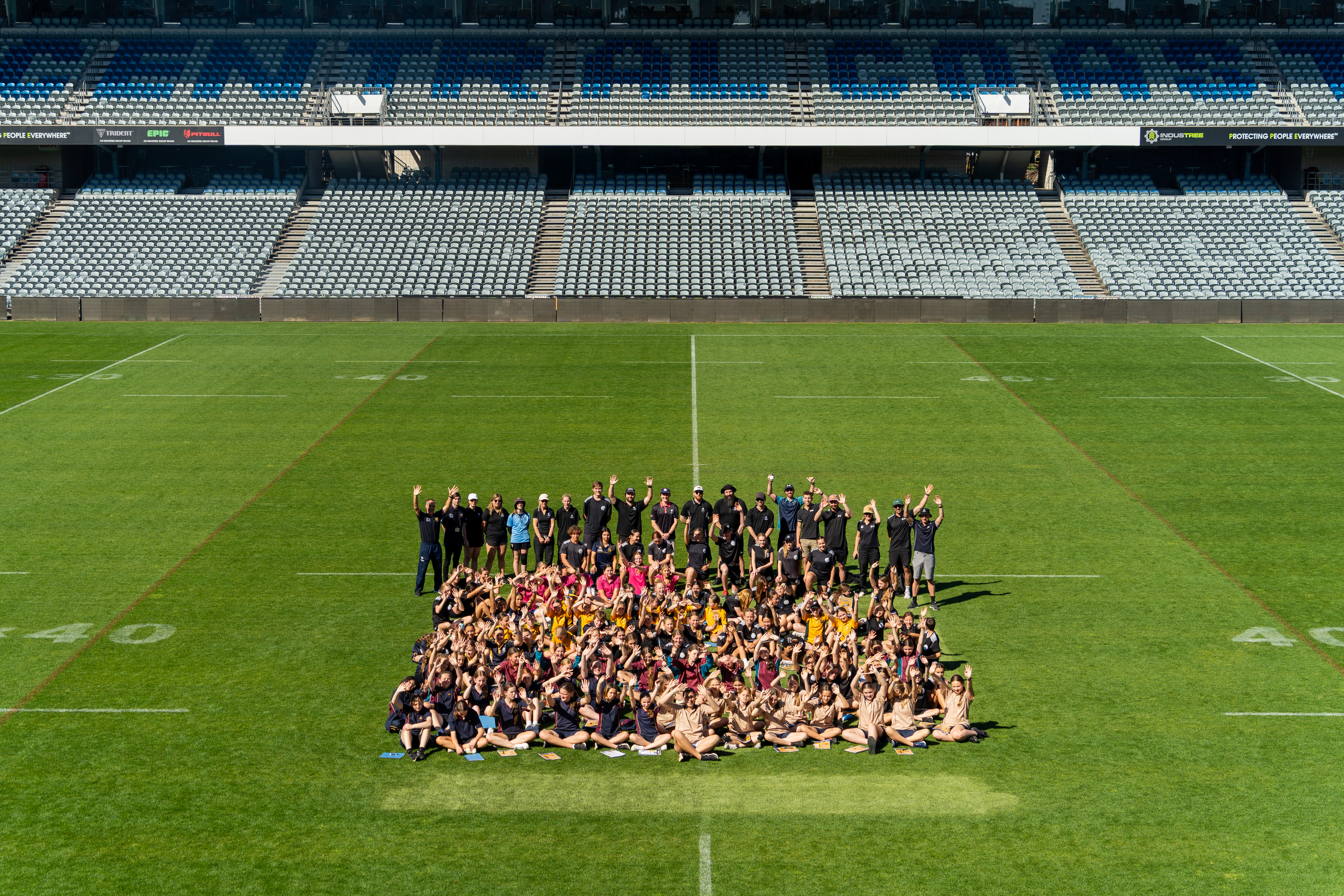A group shot of the school students, teachers, and staff on the field at Industry Stadium, Gosford A group shot of the school students, teachers, and staff on the field at Industree Stadium, Gosford