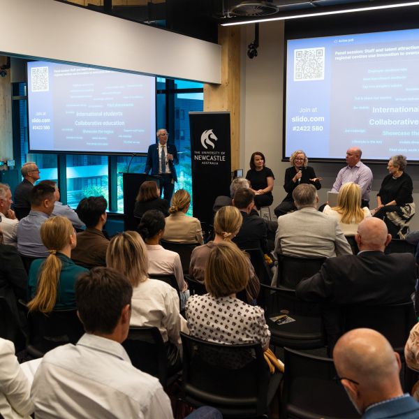 The panel of four discusses in front of the audience. A Tale of Two Cities: Hunter and Illawarra regions collaborate to unlock innovation to drive change
