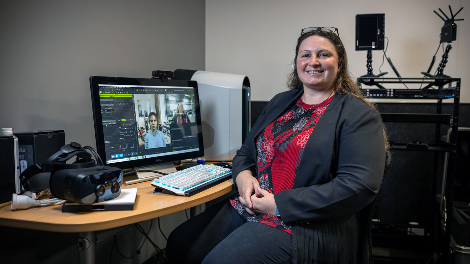 Dr Jacqueline Bailey at her computer with an avatar on screen