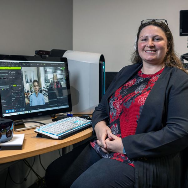 Dr Jacqueline Bailey at her computer with an avatar on screen