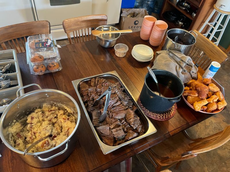 Dining table with prepared food on it ready to be served, included bison, elk, chokecherries, fry bread and saskatoon berry.