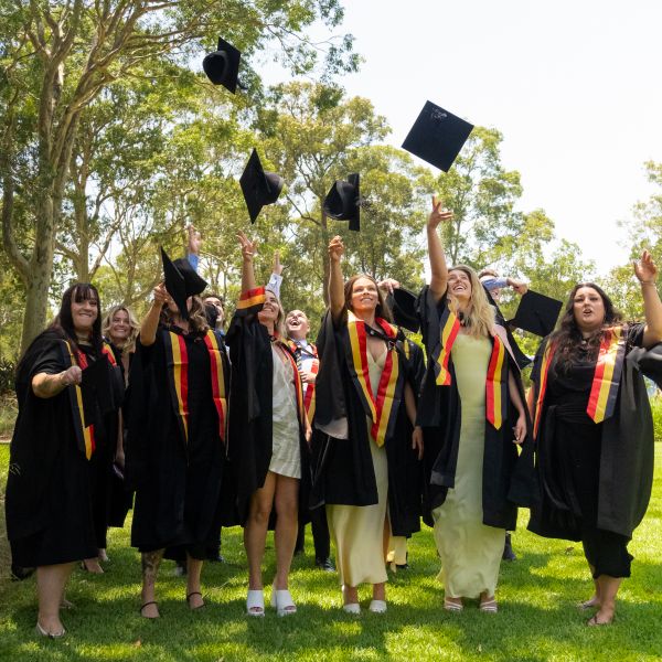 Graduating Indigenous doctors throw their caps into the air. Education that empowers: University of Newcastle celebrates record graduation.