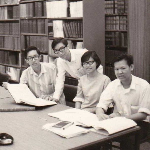 A black and white image of four students from Singapore in a library.. Celebrating 60 Years of Newcastle and Singapore.