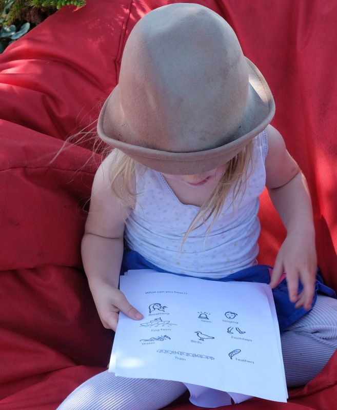 Child sitting on a beanbag looking at sheets of paper