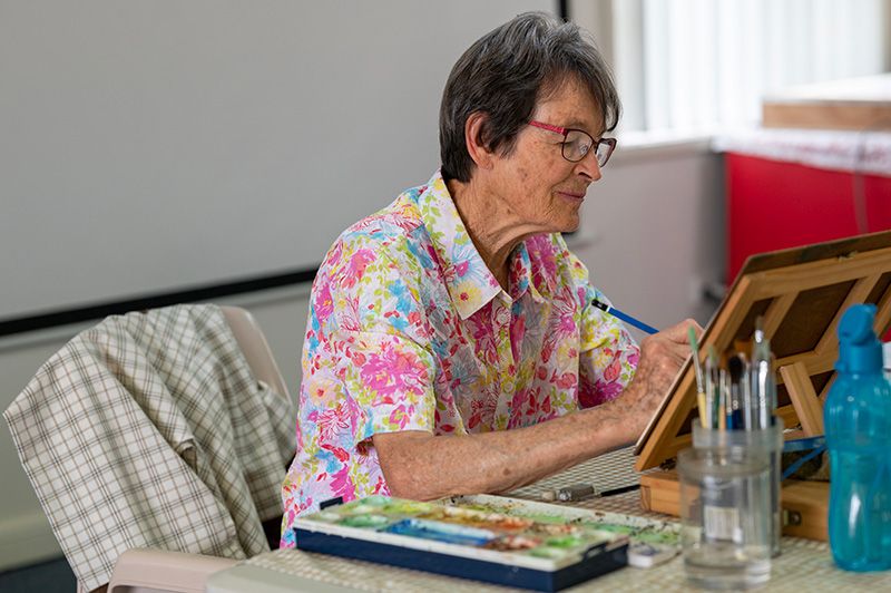 An elderly woman writing