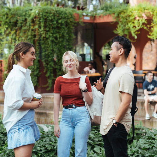 three students standing around 