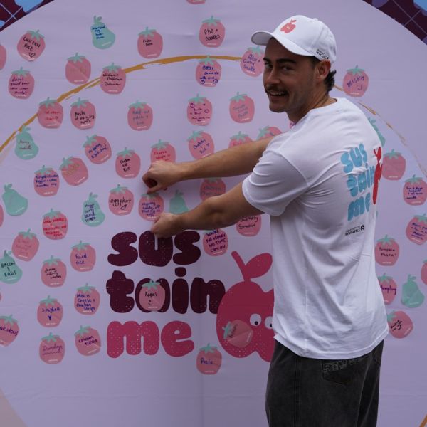 A student puts a sticker on the sustain me wall of meal ideas