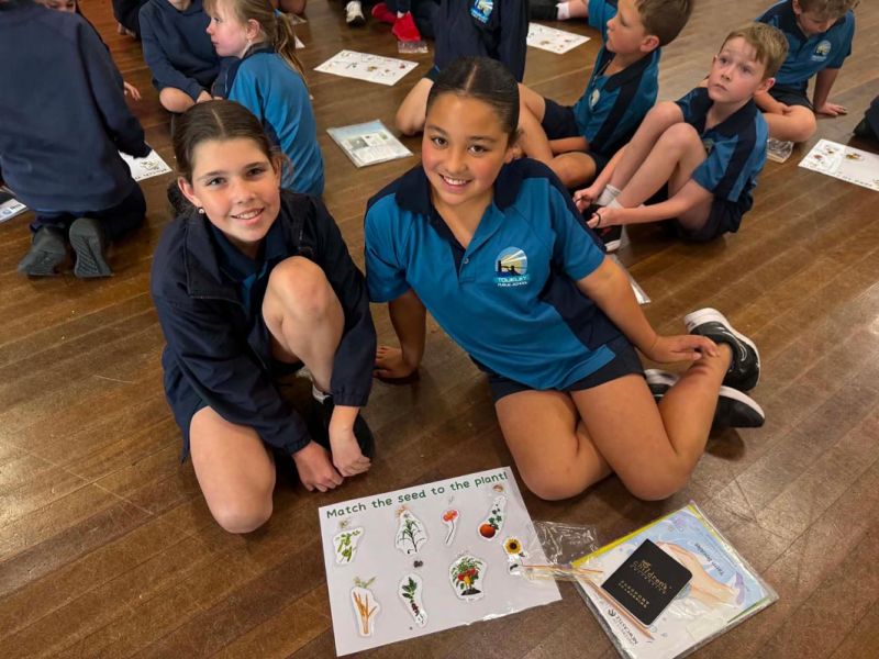 Two children sitting infront of their match their seed to the plant activity