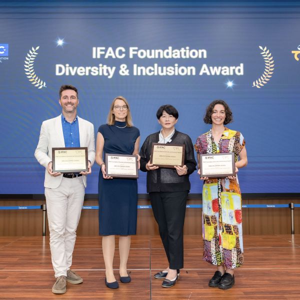 Dr Roxy Jackson (right) pictured holding a certificate with 3 other peers