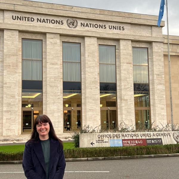 A woman standing in front of a United Nations building
