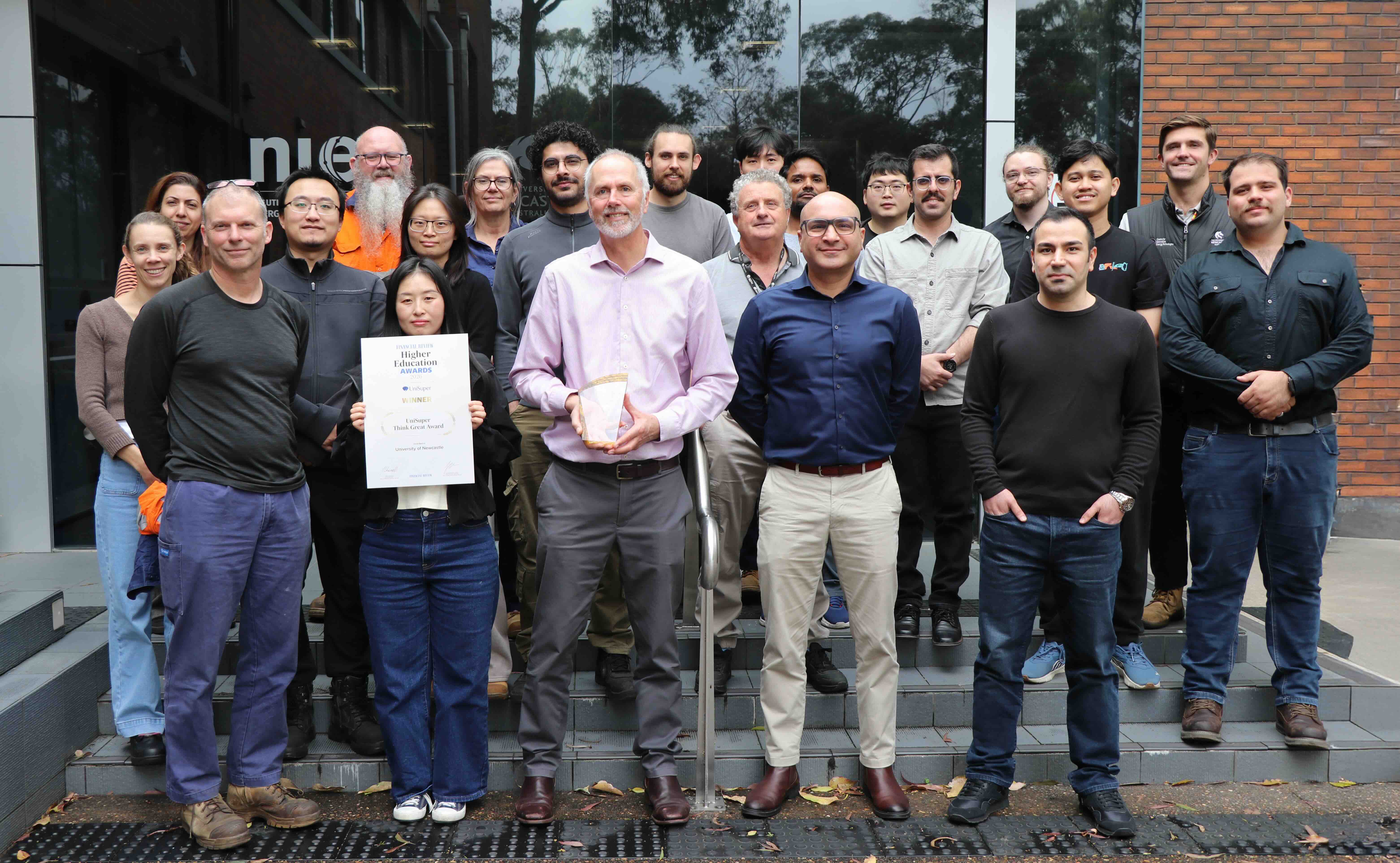 BHP SSR Team The BHP SSR team standing together for a group photo, smiling at the camera. Two members at the front are holding a trophy and a large certificate.