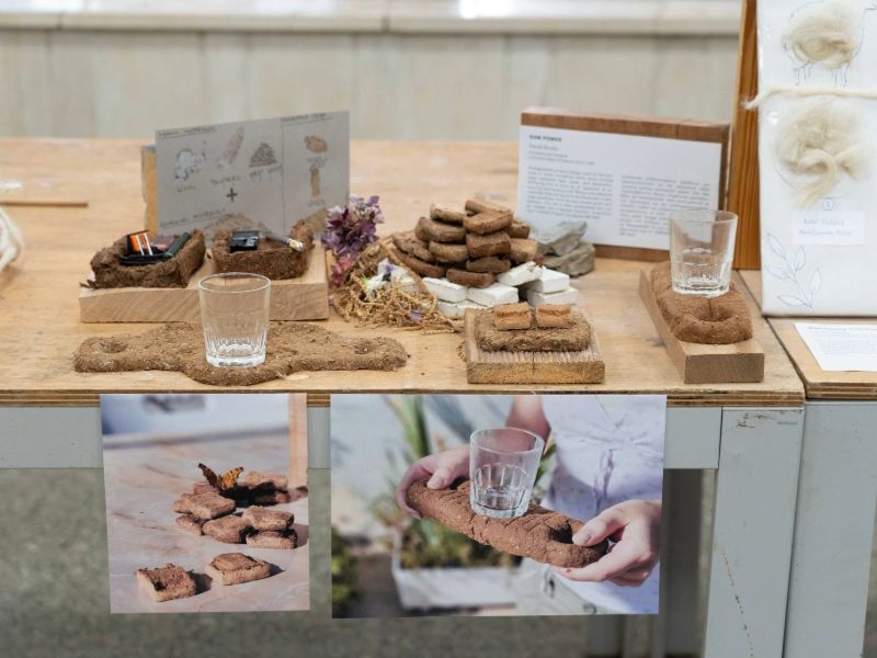 A table displaying a book, a glass of water, and a plate of cookies arranged neatly.