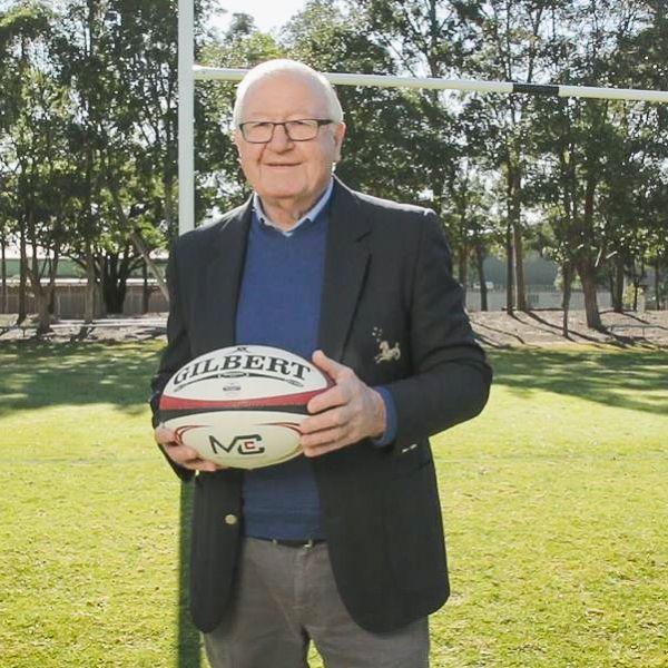 Bernie Curran stands on Oval One holding football