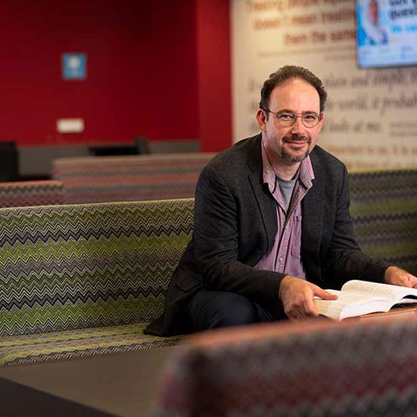 Sacha Davis Dr Sacha Davis sitting on couch reading book