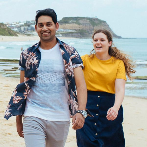 Two people walking on the beach. NUmates wins Excellence in Student Engagement award