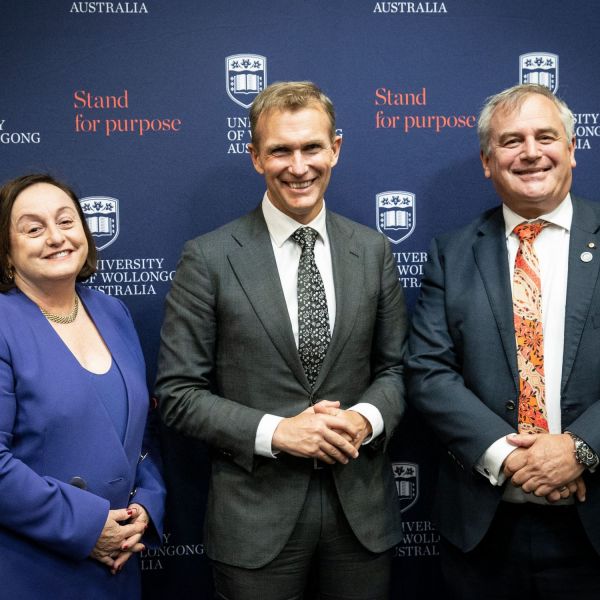 Three people smiling towards camera.. From commitment to action: The journey to a low emissions future.