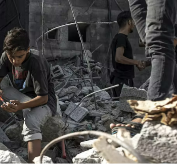 Image of a young boy sitting on on rubble 