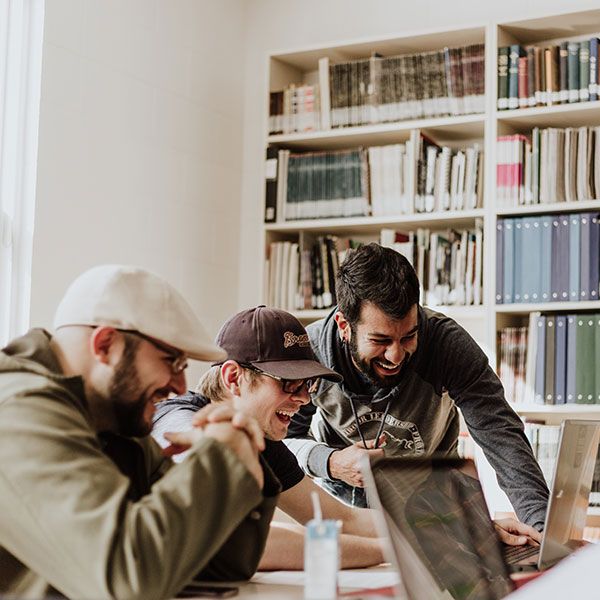 Group of students laughing whilst working