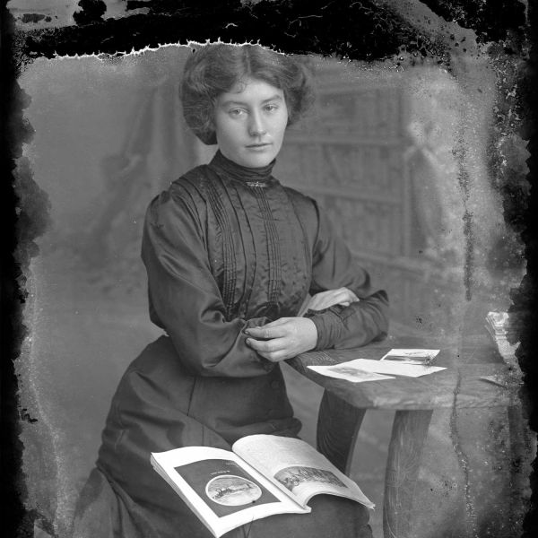 image of a lady in the mid 19th century posing with open books