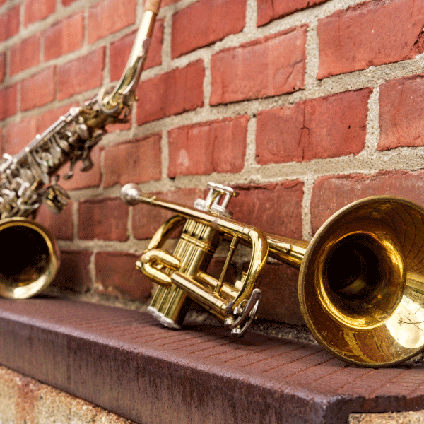 Variety of brass instruments sat next to brick wall