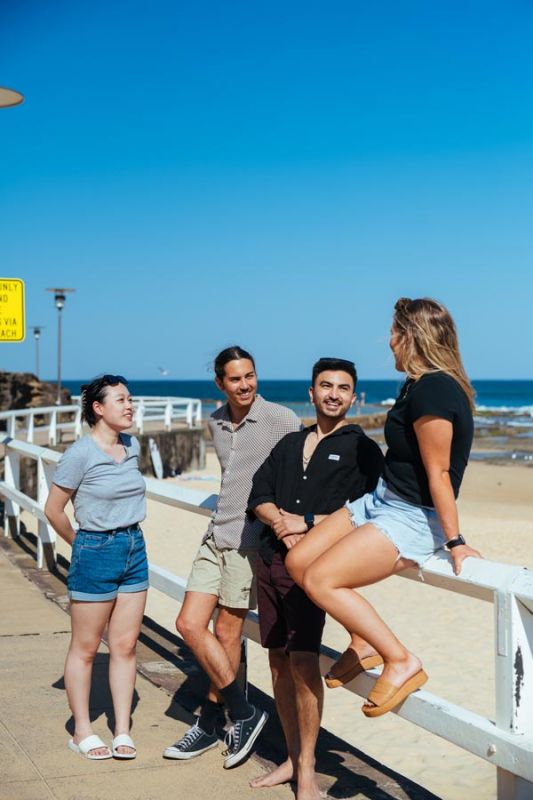 A group of four students sitting at the beach
