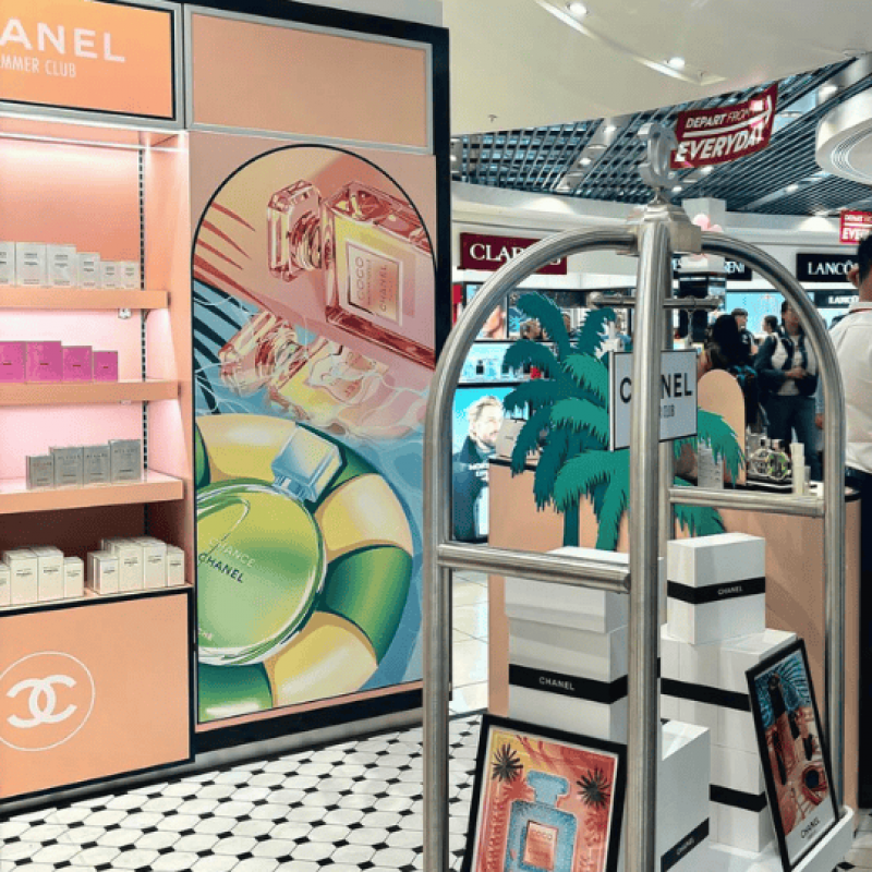 A promotional cart at a beauty department featuring a Chanel display in Singapore airport.