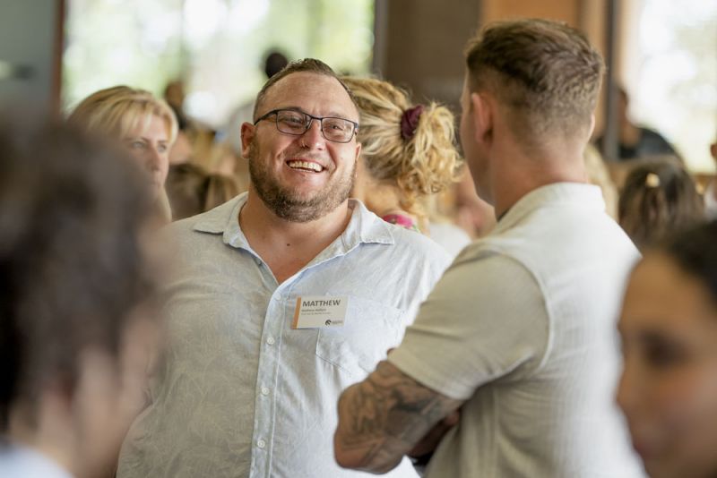 Two men talking in a large group