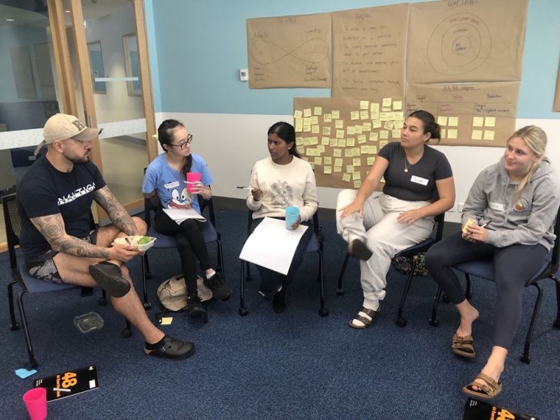 A group of people sitting in chairs in circle