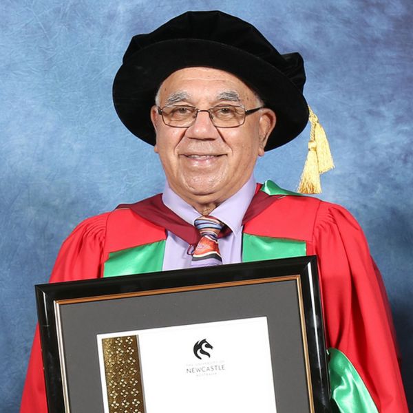 Professor Bob Morgan smiling with copy of doctorate