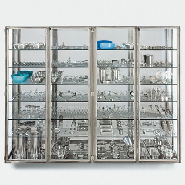 Society, Health and Care Research Symposium  glass display cabinet showcasing stainless steel kitchen utensils and a few blue bowls.