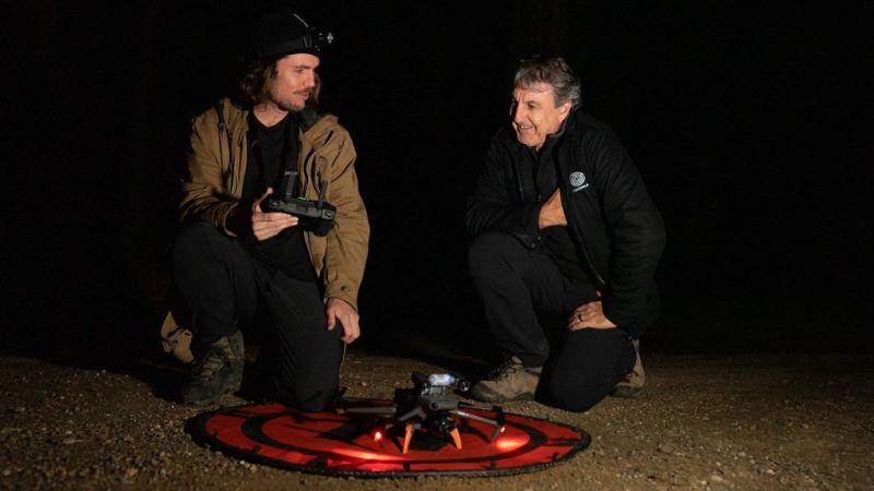 Dr Ryan Witt and Daryn McKenny pictured crouching with a thermal drone at night