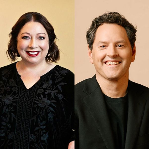 Two studio-style portraits placed side by side show two individuals smiling against neutral beige backgrounds, one wearing a black embroidered top and the other wearing a dark jacket and shirt.