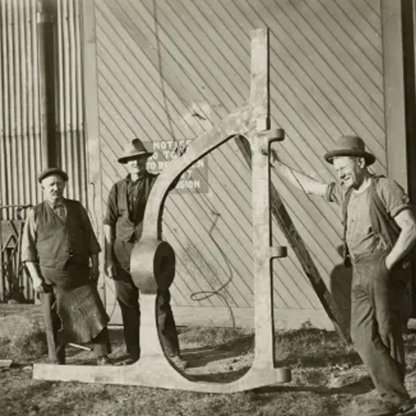 Three Men standing with Rudder Post at Walsh Island Dockyard, 1929