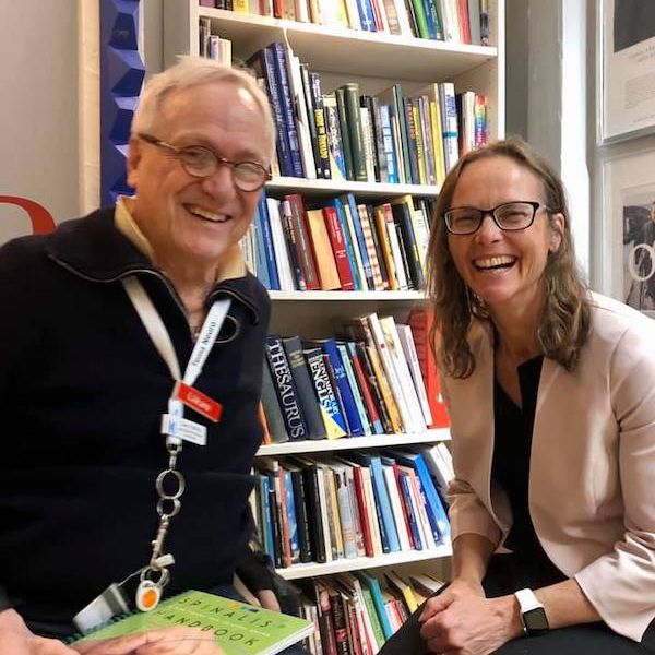  Professor Jennifer Martin smiling with Professor Claes Hultling in front of a book casein Stockholm. Sharing knowledge in Stockholm 