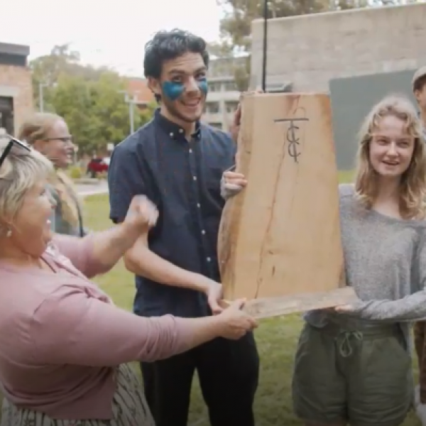 Three people holding a trophy made from a slab of timber. Being in lockdown isn’t cricket. Or is it? First year anthropology students learn through play .