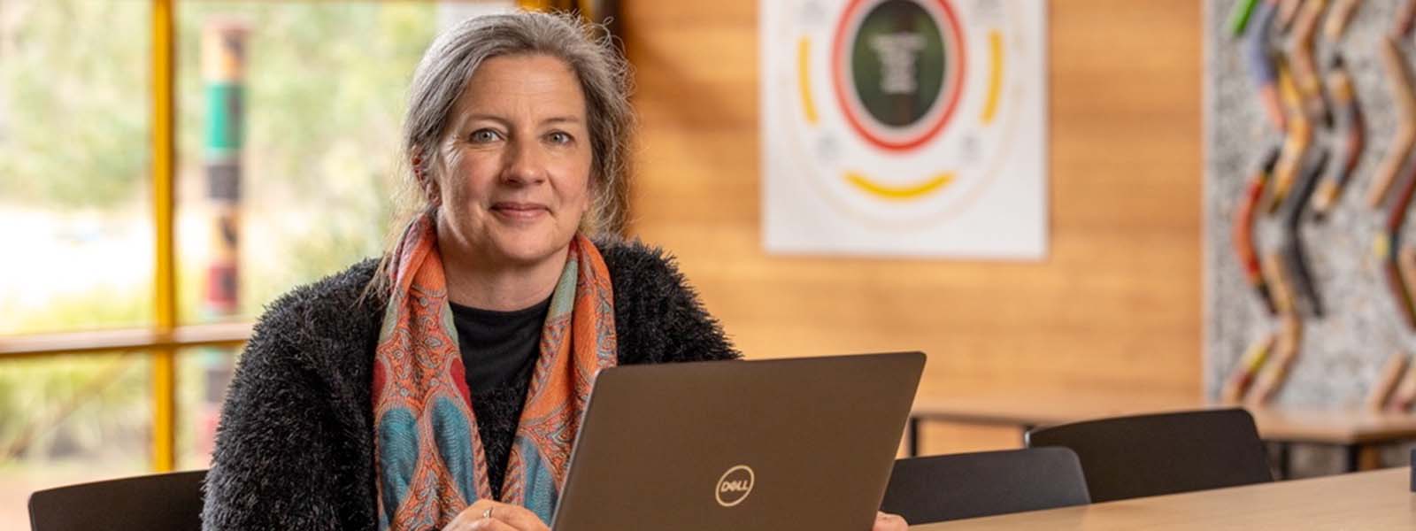 Workshop participant, Leanne Elliott, sits at a desk with a laptop