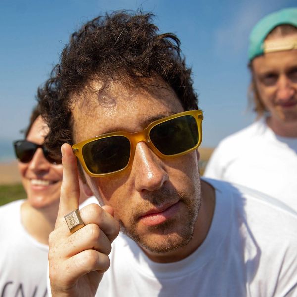 The Wombats three band members at the beach