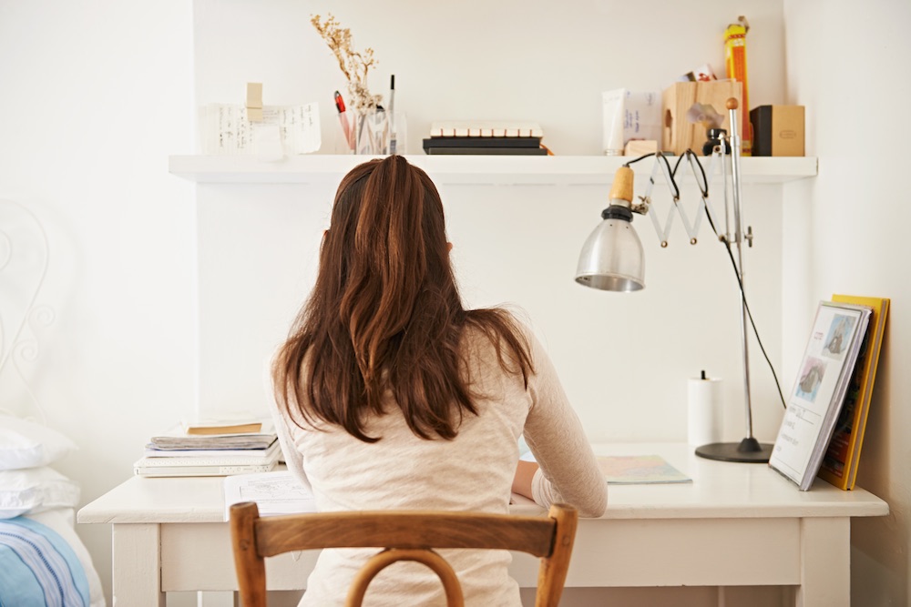 Girl sitting at a clean white desk