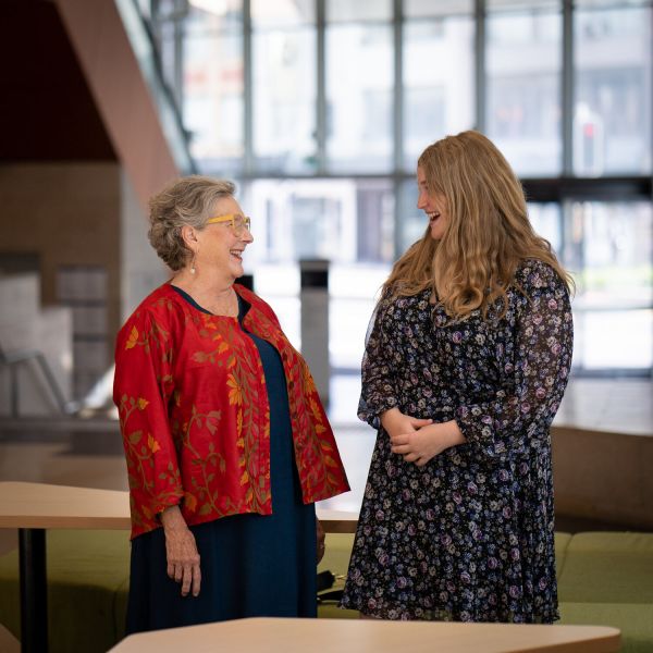 Research Roberta Ryan chatting and with a happy and smiling young person, Emma Dubos