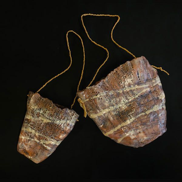 Ceramic dilly vessels with twine handles on a black background