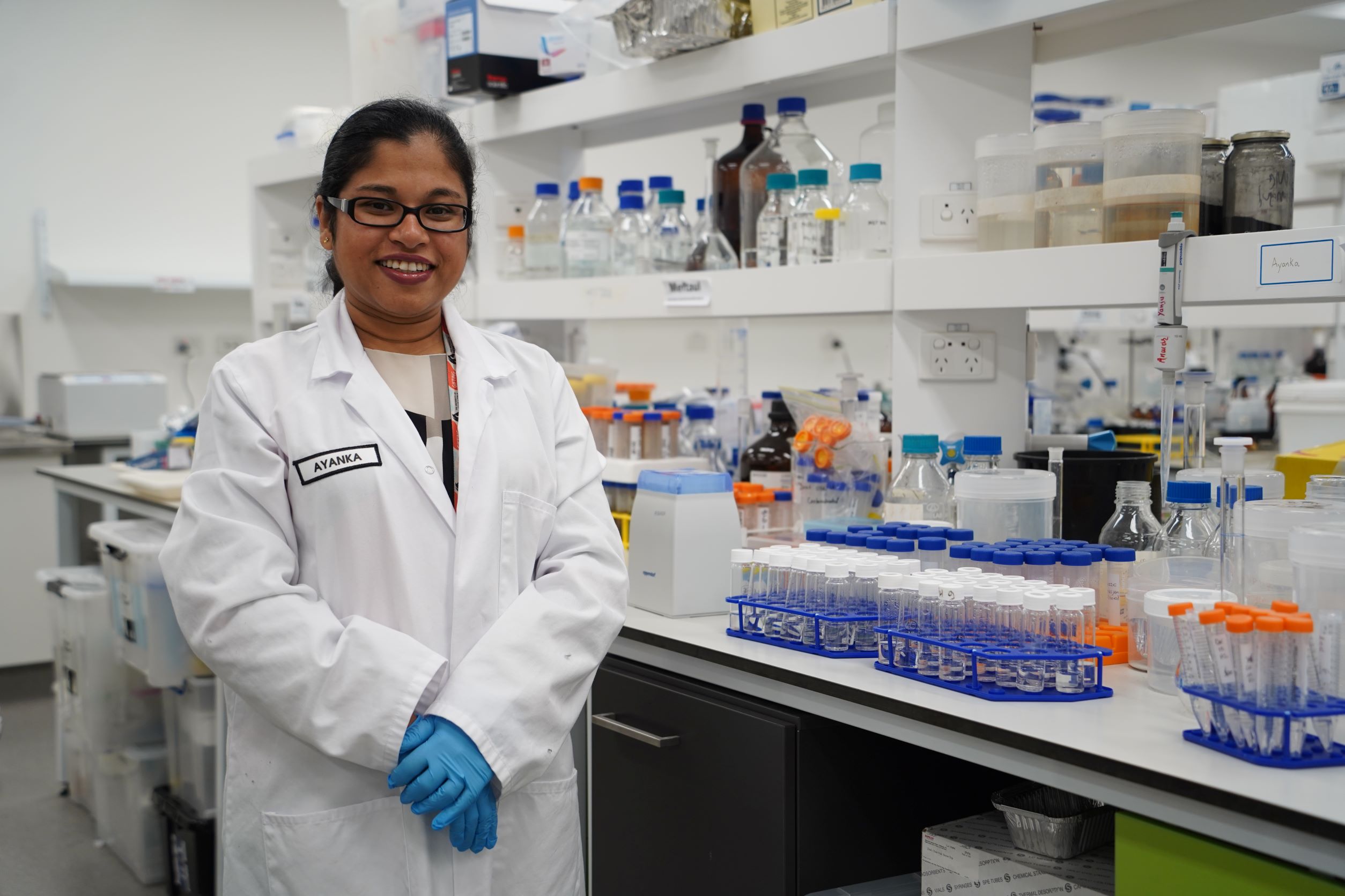 Dr Ayanka Wijayawardena stands in a lab with her lab coat one 