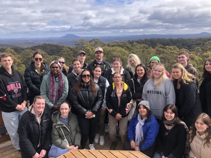A group of people smiling in front of a lookout